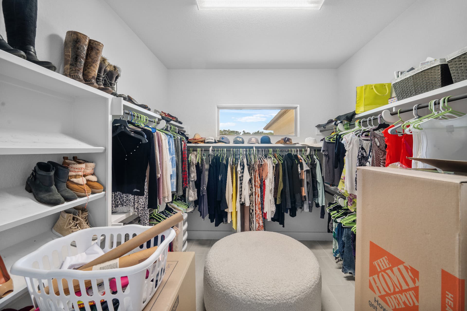 Primary closet full of clothing, shoes and moving boxes before editing